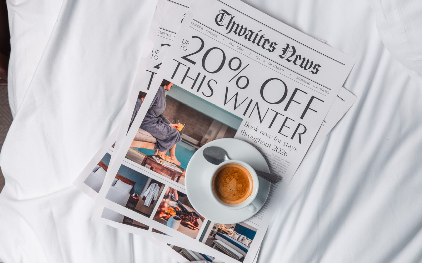 Magazine on a hotel bed with a cup of coffee that reads "Up to 20% off this winter"